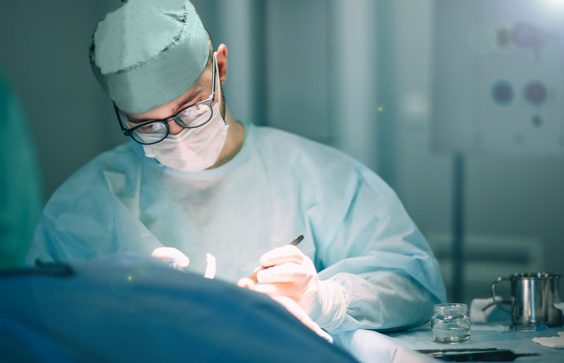 A surgeon in a hospital operating theatre carrying out an operation on a patient.