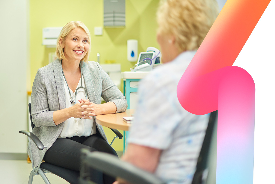A female doctor smiles as she talks to a senior patient in the clinic