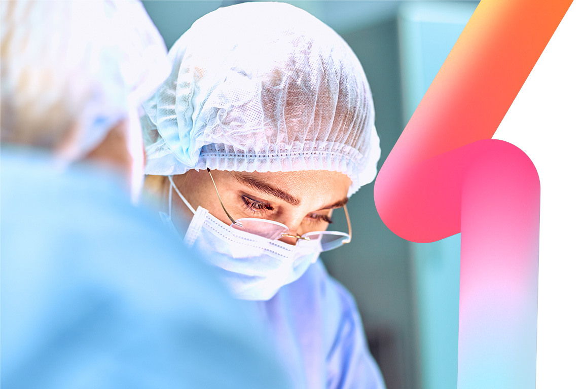 Close up portrait of young female surgeon doctor wearing protective mask and hat during the operation.