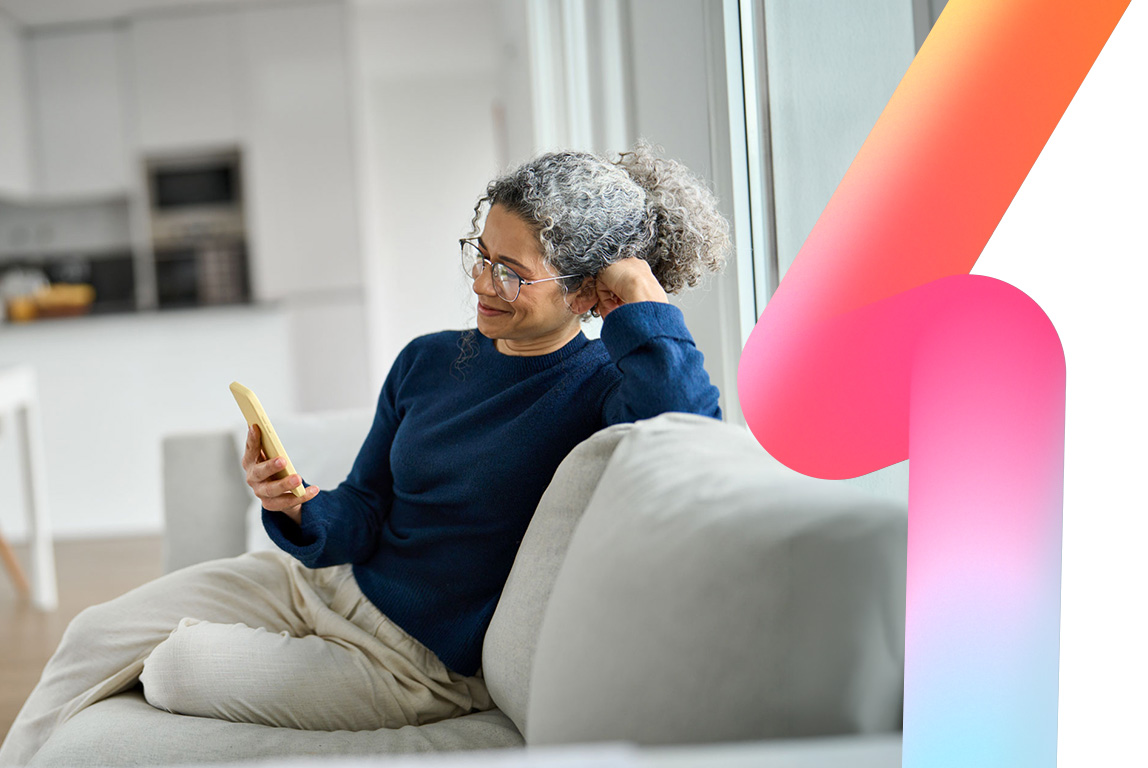 A happy middle-aged woman uses the HBS Platform on her phone at home