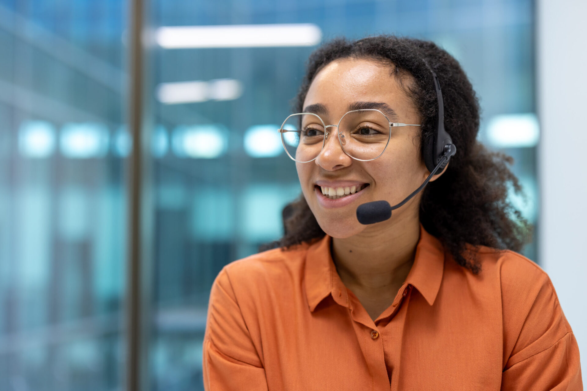 A customer support agent sat at a computer taking calls from clients
