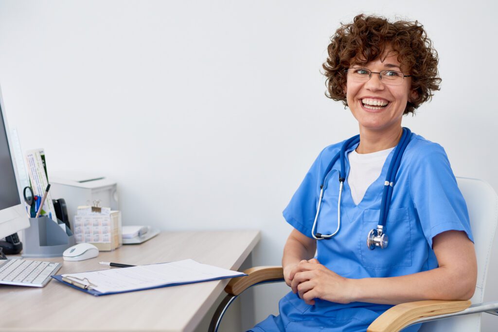 Laughing Female Doctor at Desk in Office
